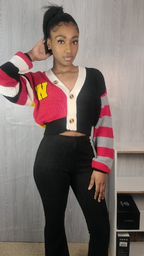 Person wearing a colorful cardigan with a red and yellow design, standing against a plain background.