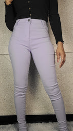 Person wearing light purple jeans and a black top on a neutral background