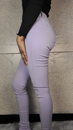 Person wearing light purple leggings on a neutral background